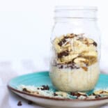Almond joy overnight oats in a mason jar sitting on a turquoise plate.
