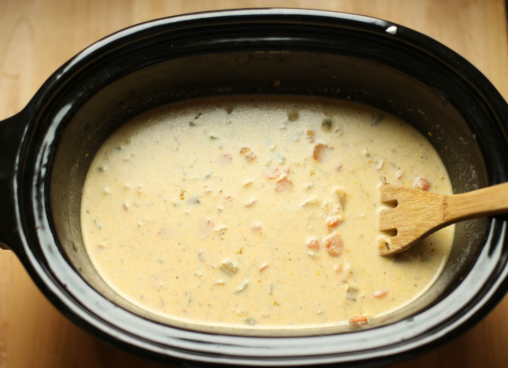 Potato soup in a slow cooker with lid off.