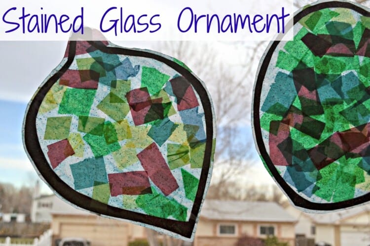 Stained glass ornament crafts mad of tissue paper squares hanging on a window.