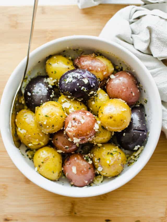 Boiled baby potatoes in a white bowl.