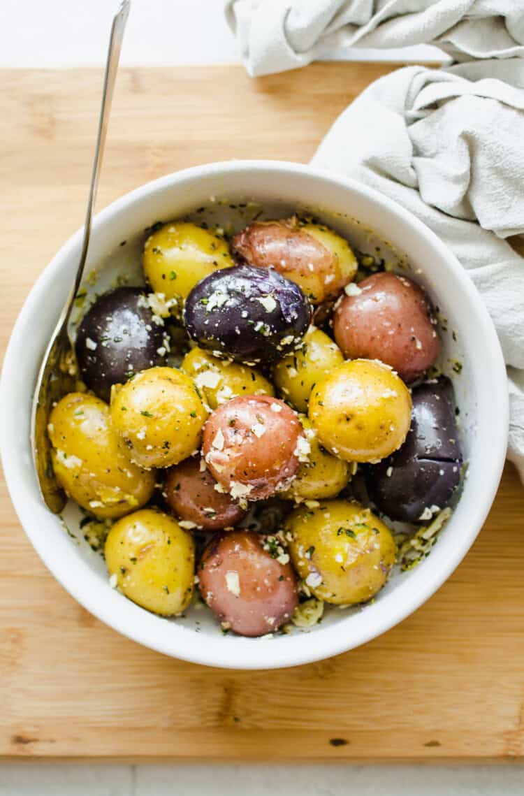 Boiled baby potatoes in a white bowl.