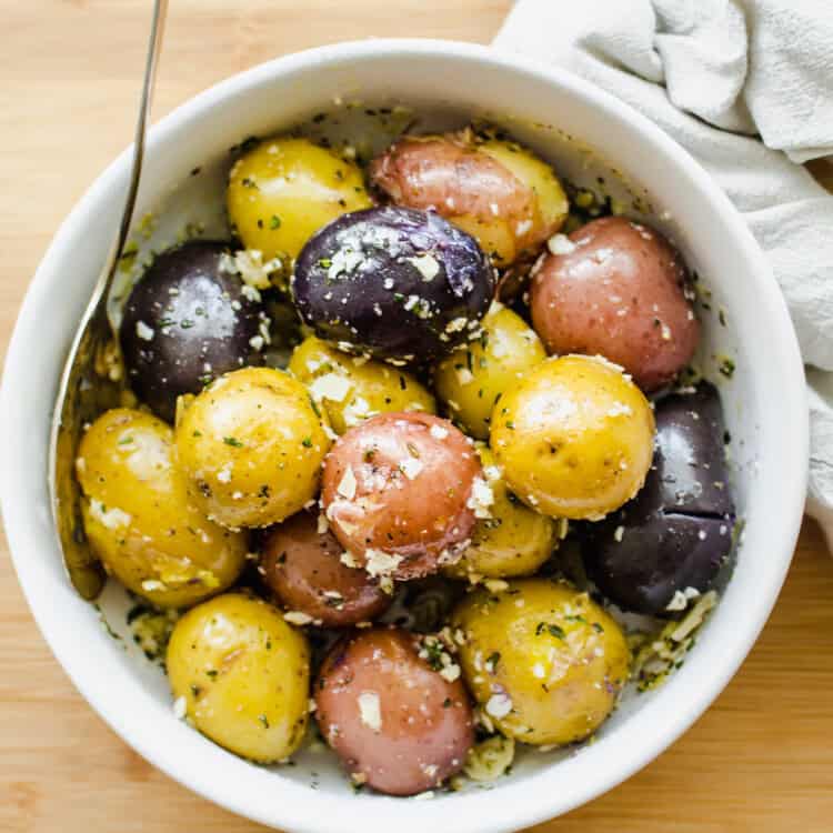 Boiled baby potatoes in a white bowl.