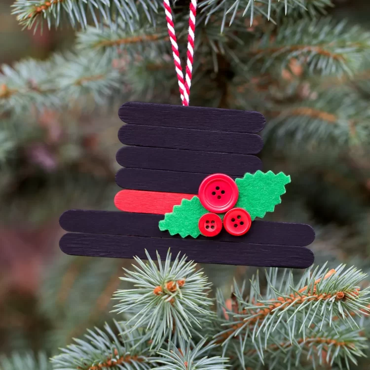 Popsicle sticks glued together in the shape of a top hat, painted black with one painted red like a ribbon around it.