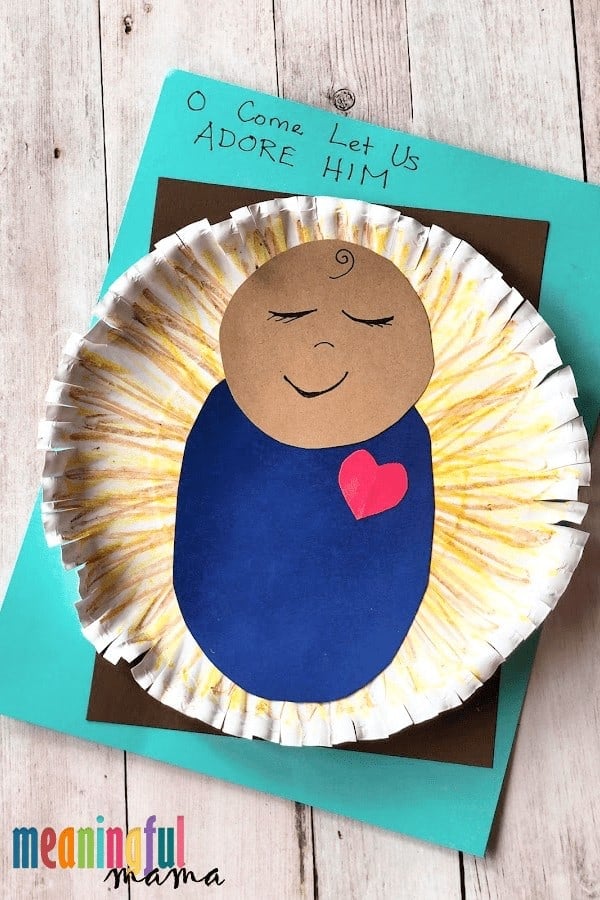 Baby Jesus made of construction paper cutouts glued onto a paper plate colored yellow with slits all around the edge of the paper plate to mimic straw.