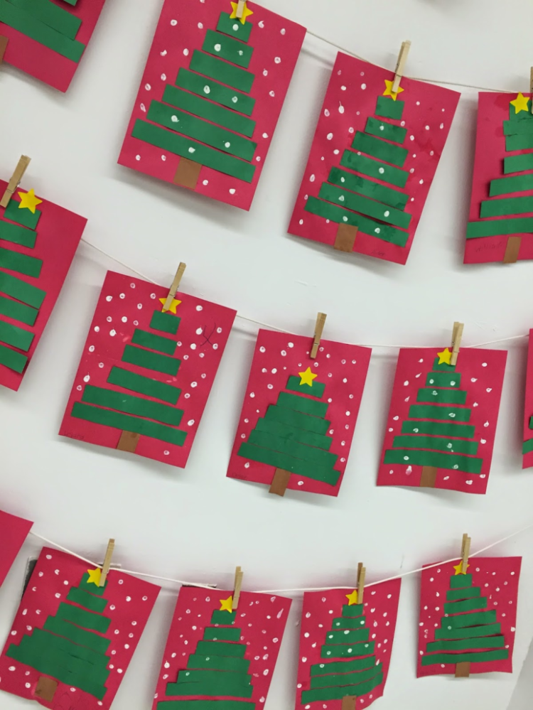 Christmas trees made of green paper strips glued to red paper with a gold star on top.