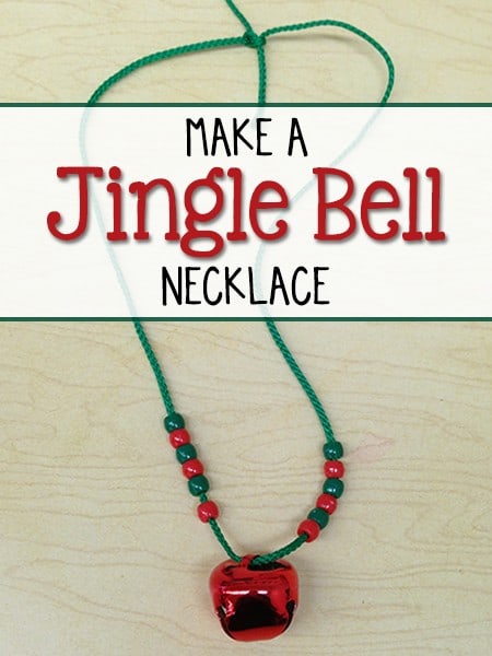 A red jingle bell on a green cord with red and green beads to make a jingle bell necklace.