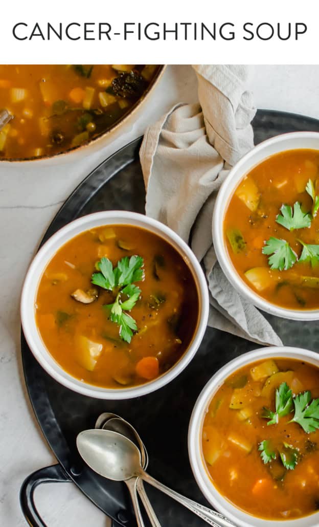 Large pot of vegetable soup with three bowls of vegetable soup. Spoons and napkins and fresh herbs on the side.