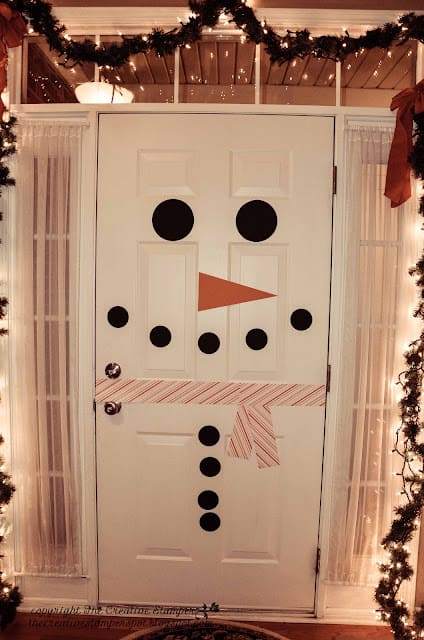 A white door decorated with construction paper pieces to look like a snowman.