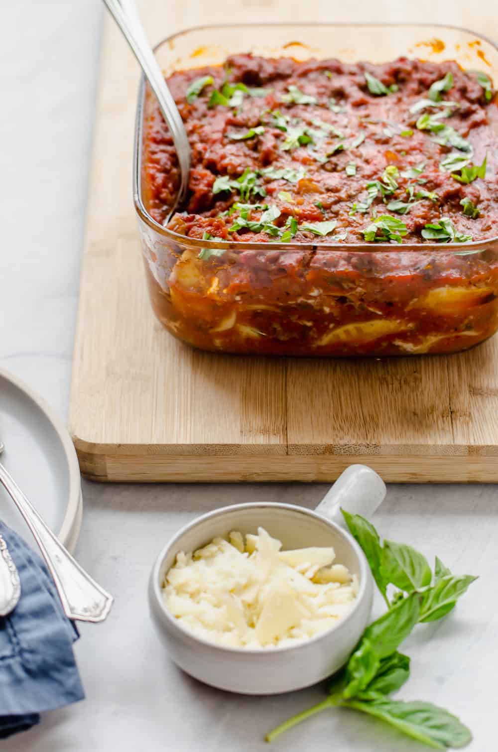 Beefy Baked Ravioli in a baking dish with a serving spoon in it.