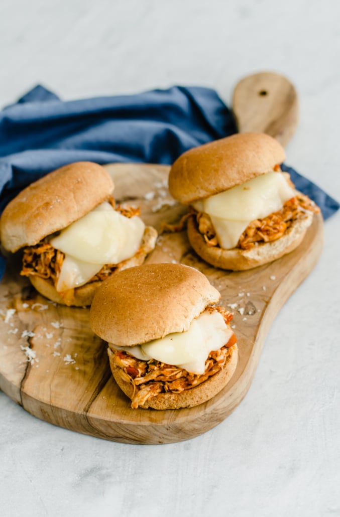 Slow Cooker Chicken Parmesan Sliders on a cutting board