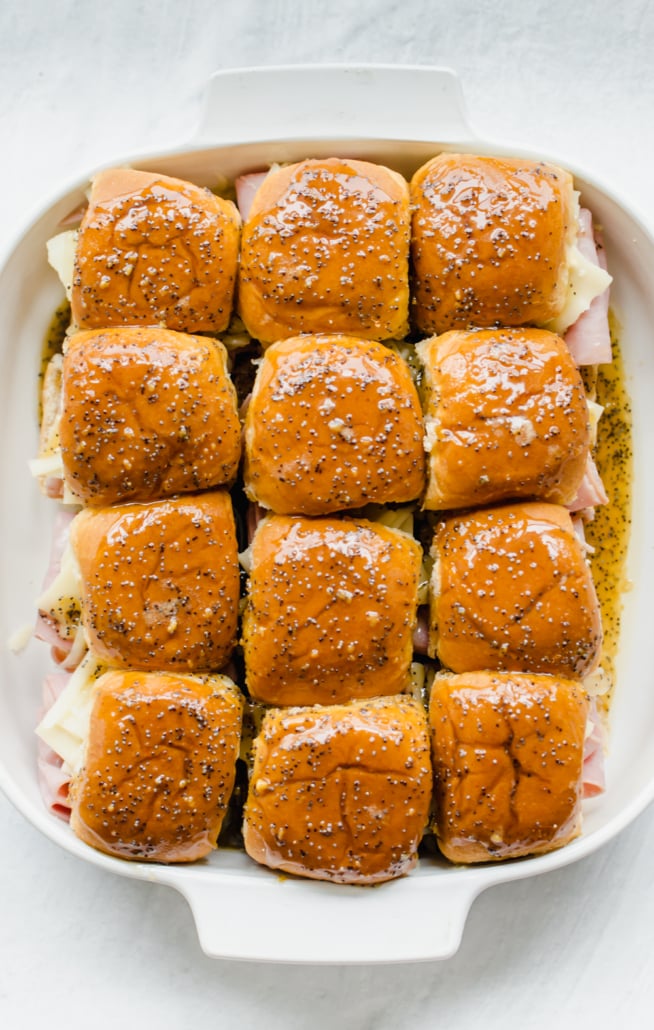 Ham and cheese sliders in a white baking dish