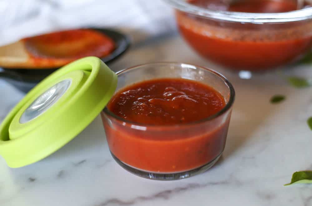 Homemade pizza sauce in a freezer container.