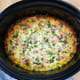 Breakfast Casserole in a Crockpot on a wooden cutting board