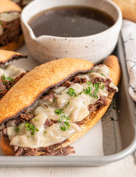 french dip sandwiches on a tray with au jus