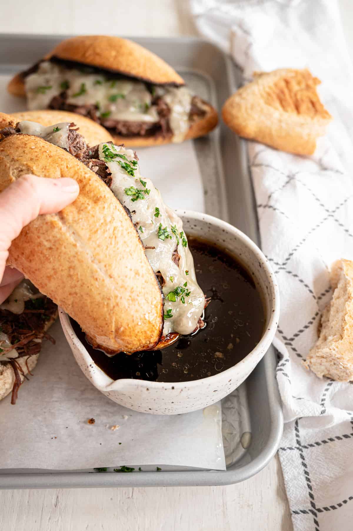 French Dip sandwich dipped in au jus sauce.