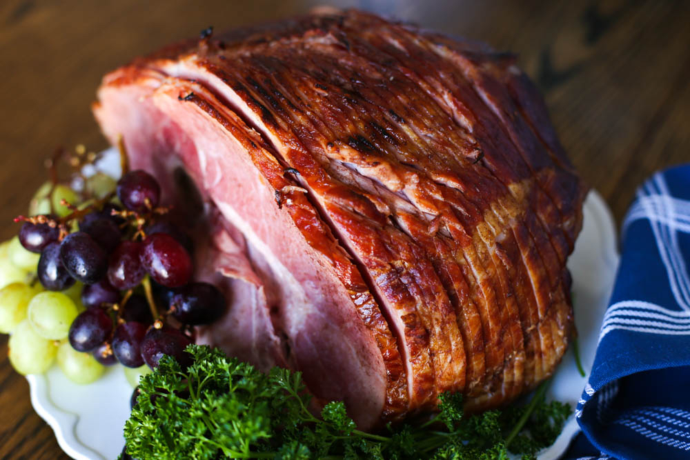 Make ahead Easter spiral sliced ham on a serving dish with parsley and grapes