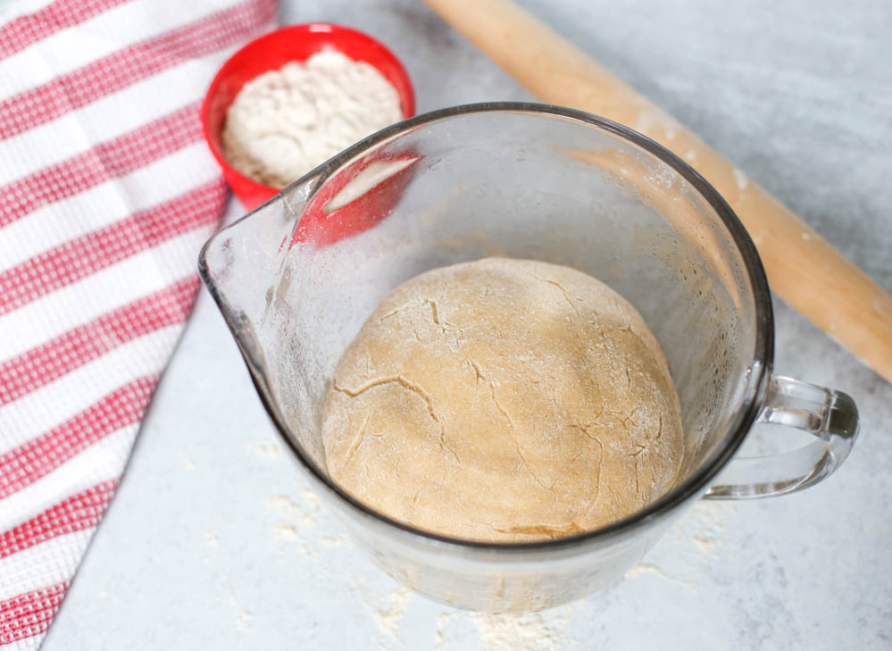  Homemade whole wheat pizza dough in a glass bowl