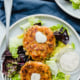 salmon cakes on a plate with lettuce and tartar sauce