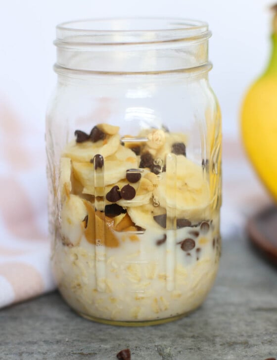 oats, peanut butter, chocolate chips, and bananas in mason jar on a counter