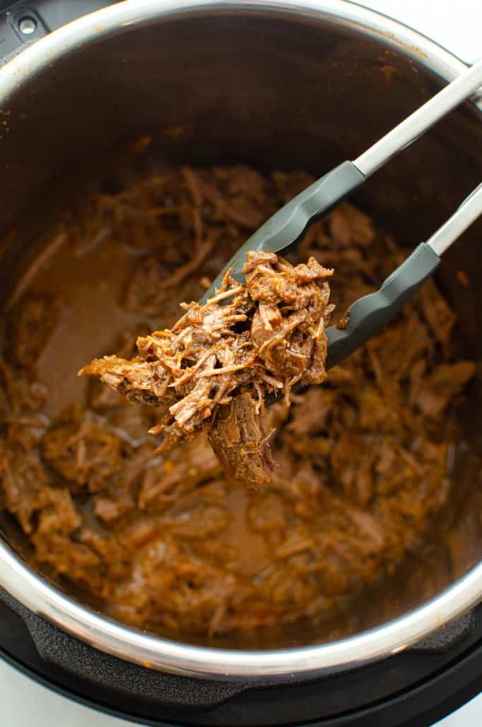 BBQ shredded beef in an Instant Pot with BBQ sauce.