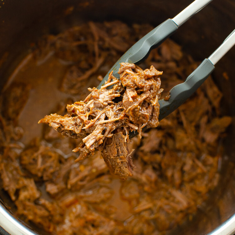 BBQ shredded beef in an Instant Pot with BBQ sauce.