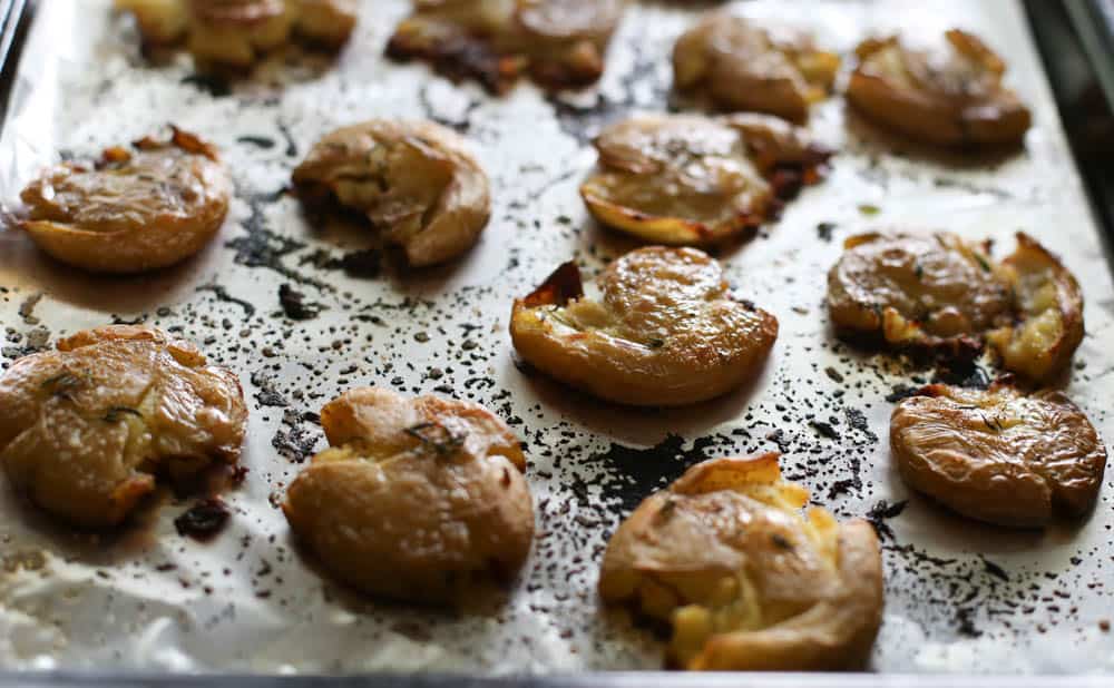 Fully cooked smashed potatoes on a foil-lined baking sheet with crispy edges.