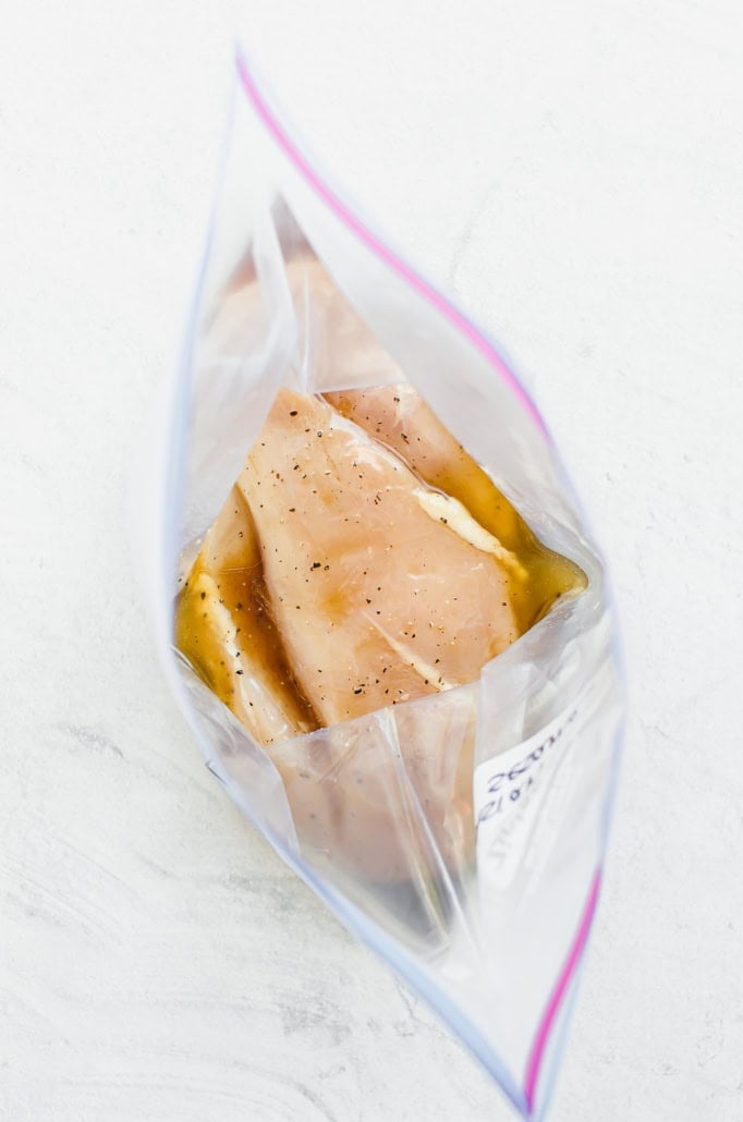 Chicken breasts in asian marinade in a gallon sized freezer bag.