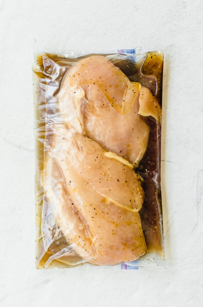 Chicken breasts in marinade in a gallon sized freezer bag.