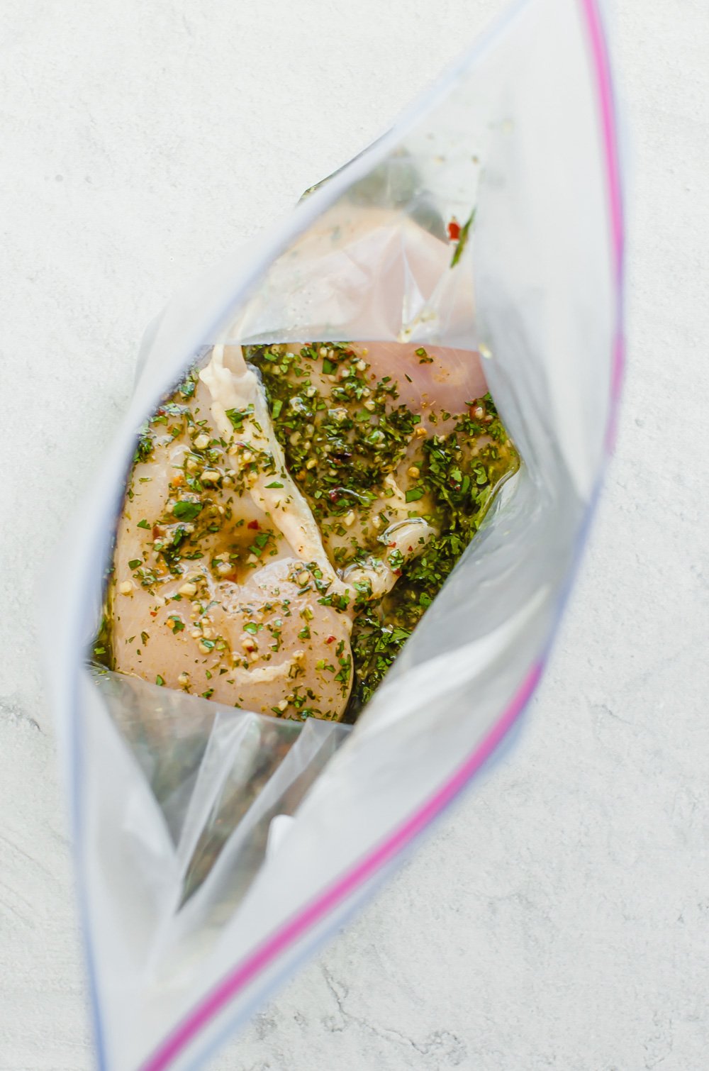 cilantro lime marinade over chicken breasts in an open freezer bag