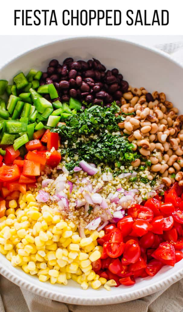 Beans, corn, and chopped peppers, herbs, and tomatoes in a white serving bowl.