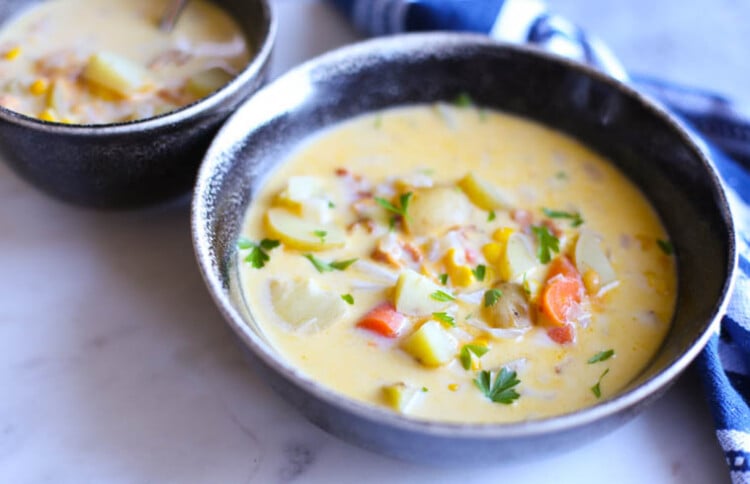 Corn and potato chowder in a bowl with fresh parsley on top.