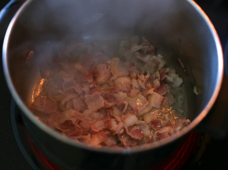 Bacon frying in a large metal pot