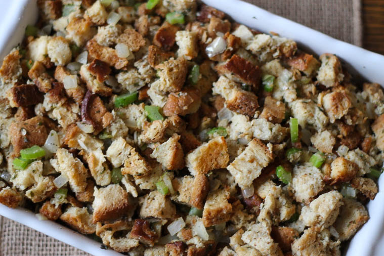 cropped picture of white casserole dish with homemade stuffing, includes bread, celery, and onion