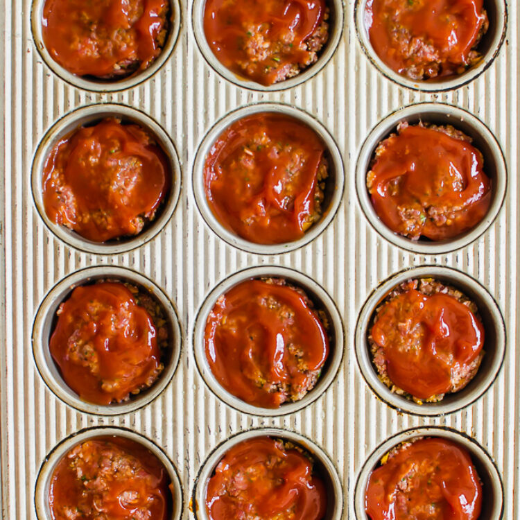 Meatloaf mixture in a muffin tin ready to bake.