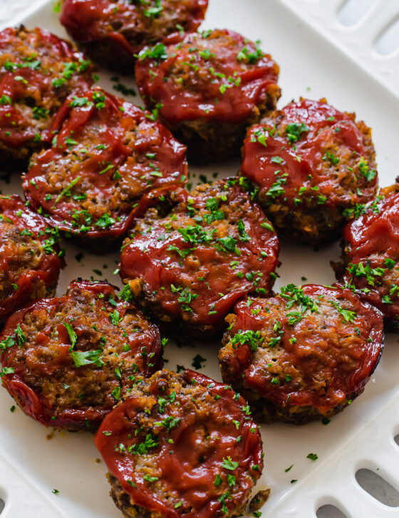 Mini meatloaf muffins lined up on a platter ready to serve.