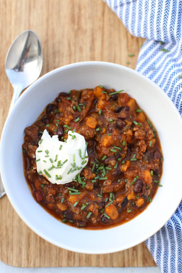 Slow Cooker Turkey Chili served in a white bowl with a dollop of sour cream.