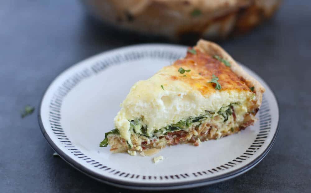 Spinach and bacon quiche slice on a plate