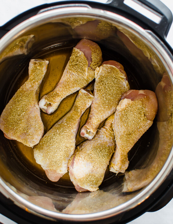 Seasoned chicken drumsticks in instant pot ready to be cooked.
