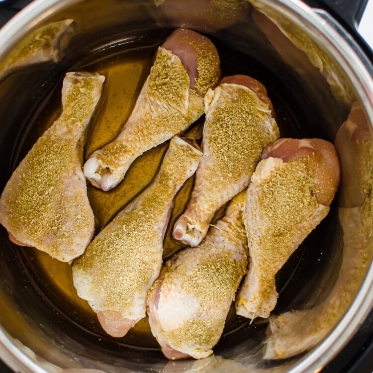 Seasoned chicken drumsticks in instant pot ready to be cooked.