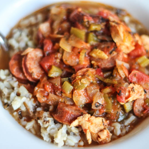 Jambalaya with chicken and andouille sausage over rice in a bowl