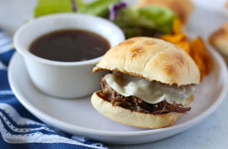 Slow cooker french dip sandwiches on a white plate