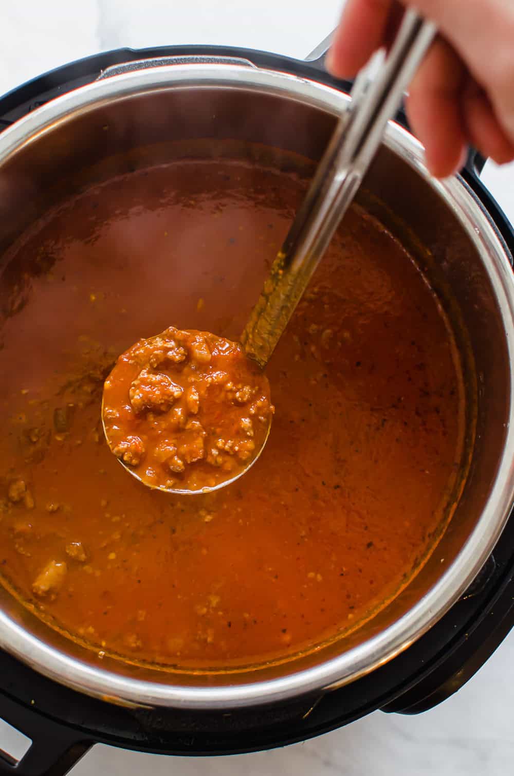 Spaghetti sauce being ladled out of the Instant Pot.