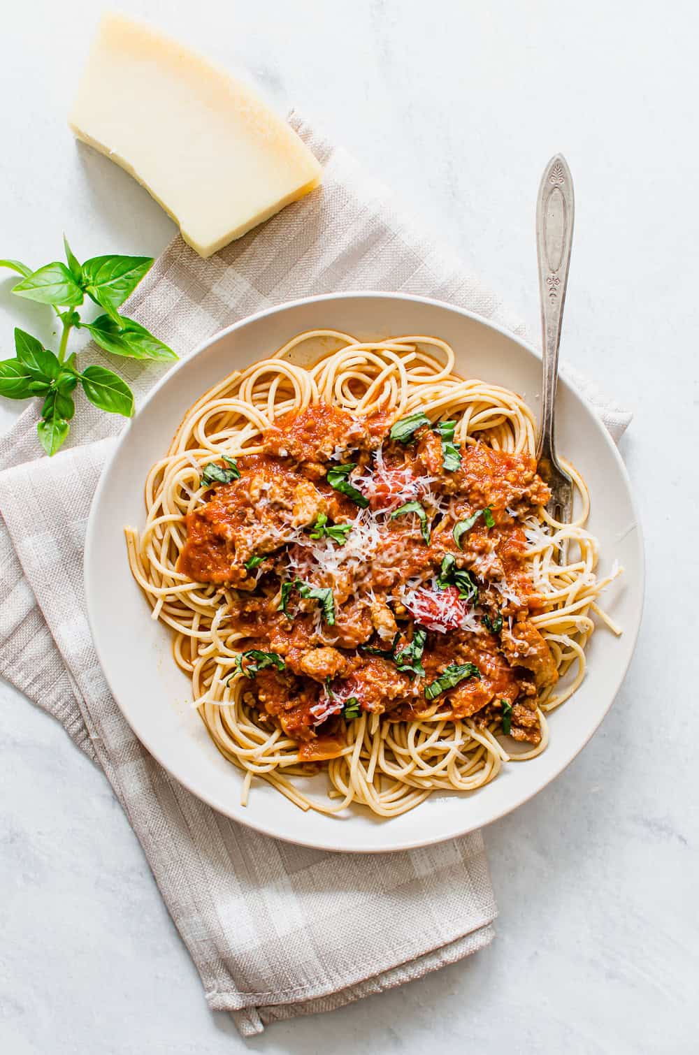 Whole wheat spaghetti with spaghetti sauce and basil on top