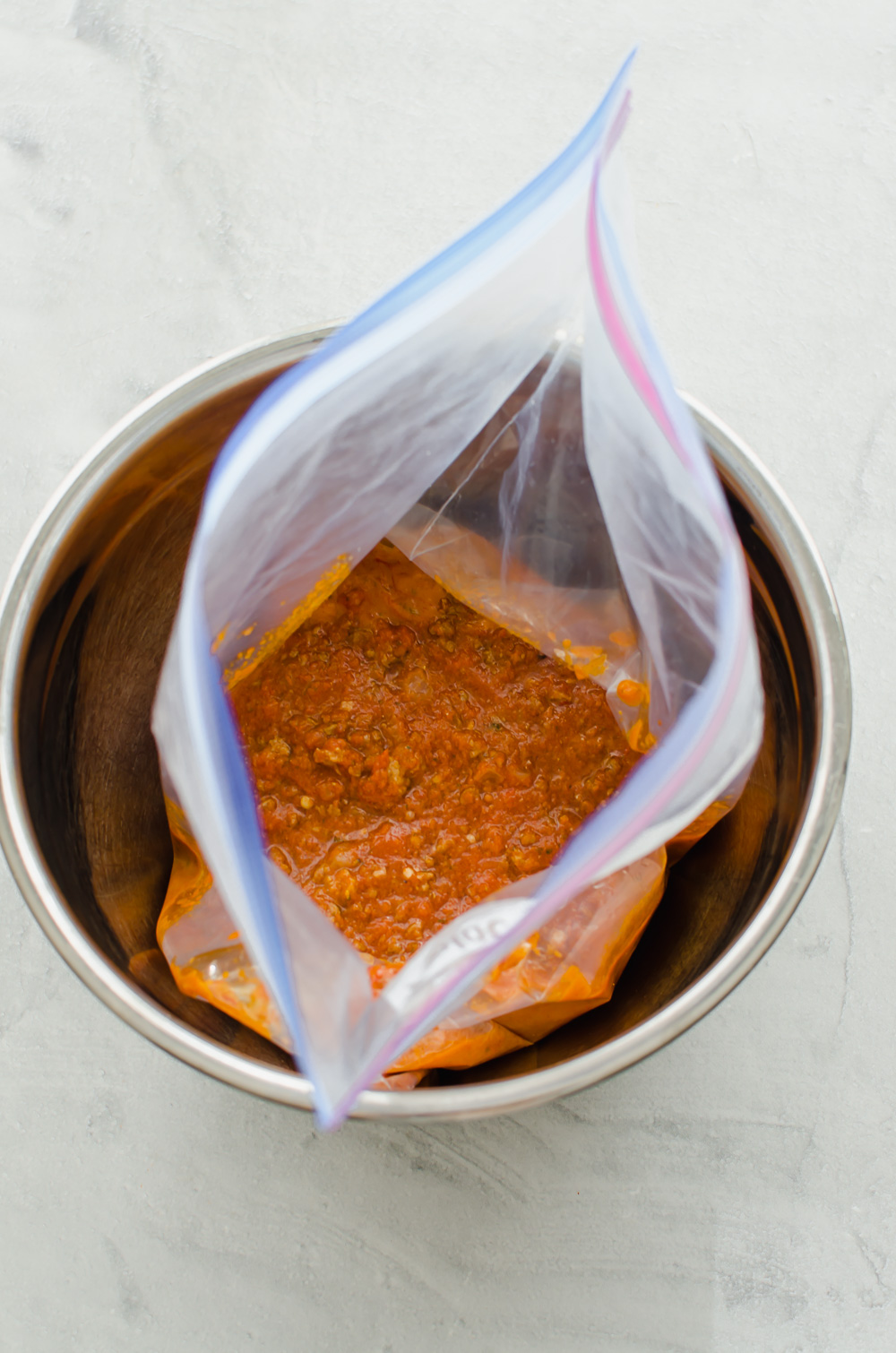 Meaty marinara sauce in a freezer bag sitting in an Instant Pot.