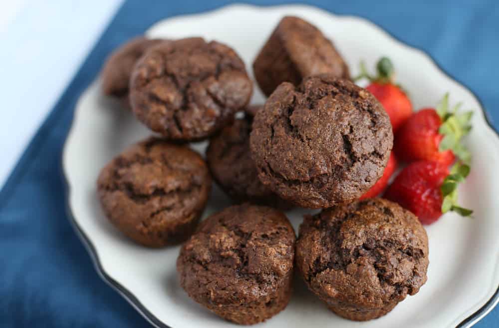 Chocolate Banana muffins stacked on a white plate.