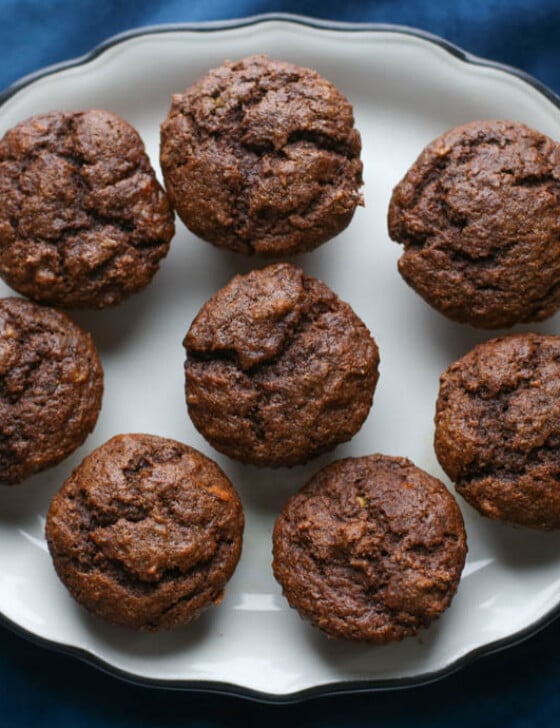 Chocolate banana muffins lined up on a white platter.