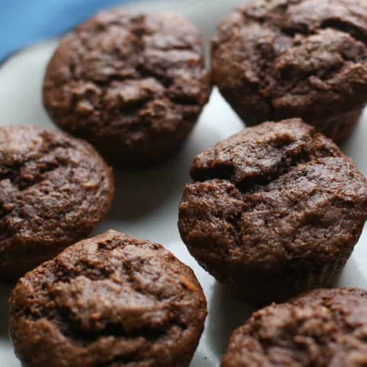 Chocolate banana muffins on a white serving platter.