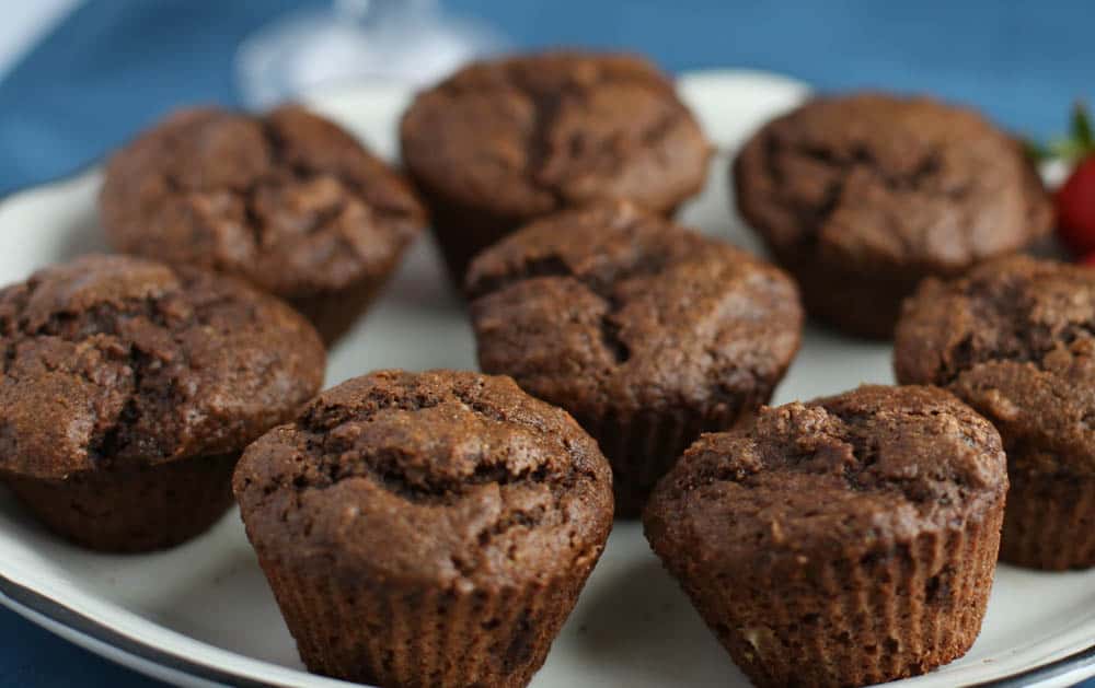 Chocolate banana muffins lined up on a serving plate.