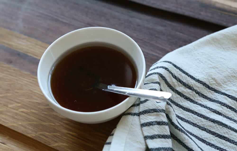 Maple syrup, coconut oil, and vanilla in a mixed together in a white bowl.