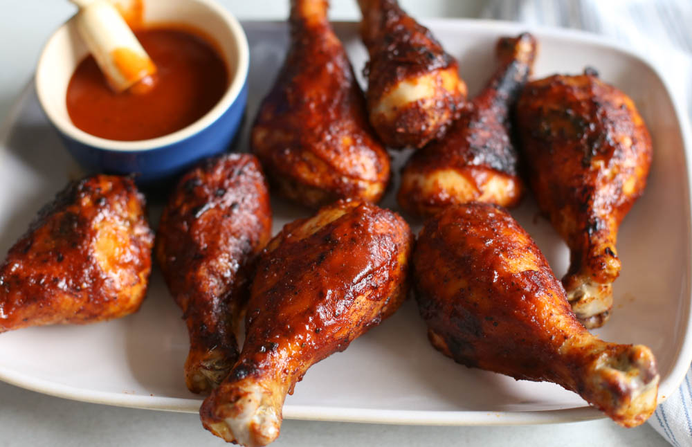 Cooked BBQ drumsticks on a white plate